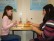 Zwei Schülerinnen sitzen an einem Tisch und fühlen, wie Stimmgabeln vibrieren.