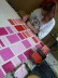 Ein Mädchen malt mit rosa Farbe einzelne Vierecke des Musters aus.