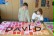 Ein Junge und ein Mädchen legen die Buchstaben D, A, V, I und D auf die fertig bemalte Hintergrundwand.