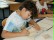 Ein Junge schneidet mit einem speziellem Werkzeug ein Muster in eine Linoleumplatte.