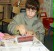 Der Junge drückt mit einer Rolle das Blatt Papier fest auf die Linoleumplatte.