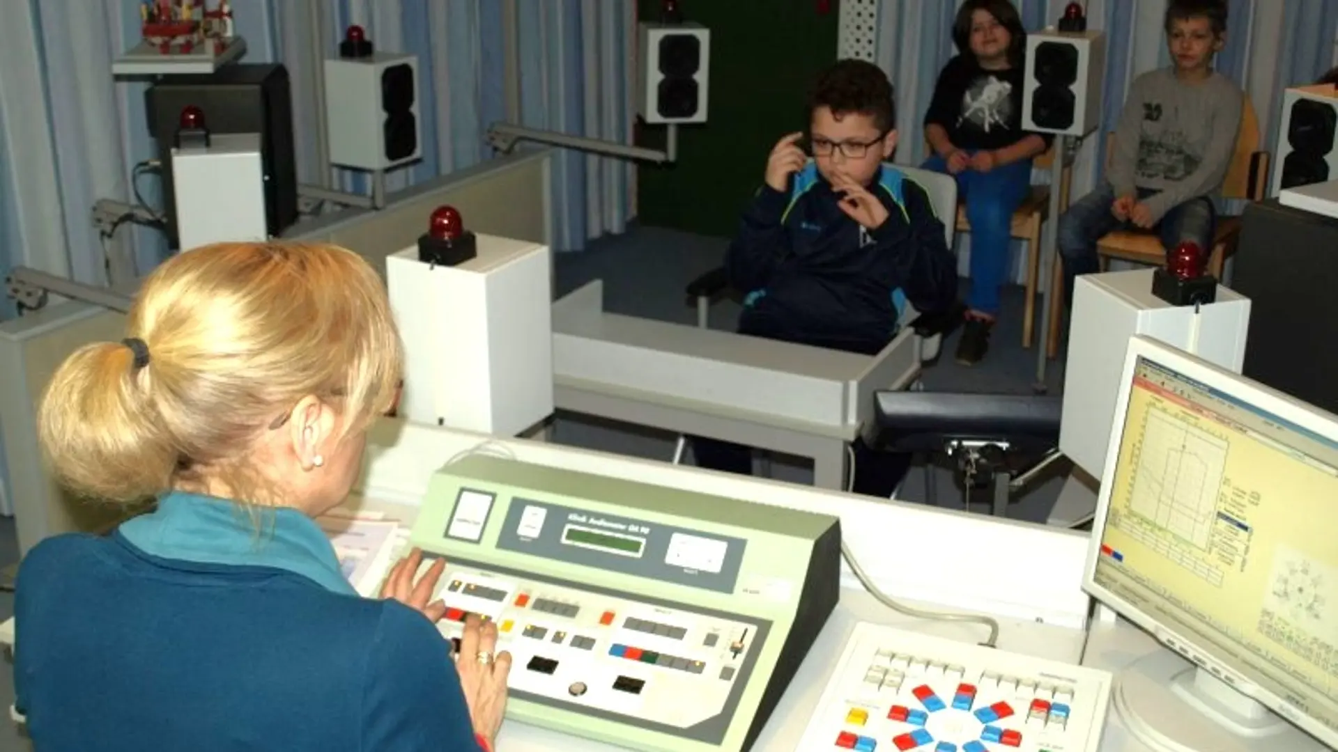 Buntes Gemälde des Maskottchens der Schule: ein fröhliches Flusspferd, dass die Arme in die Luft reckt. Es scheint zu tanzen. Es trägt ein Kleider das der Nationalflagge von Albanien entspricht.