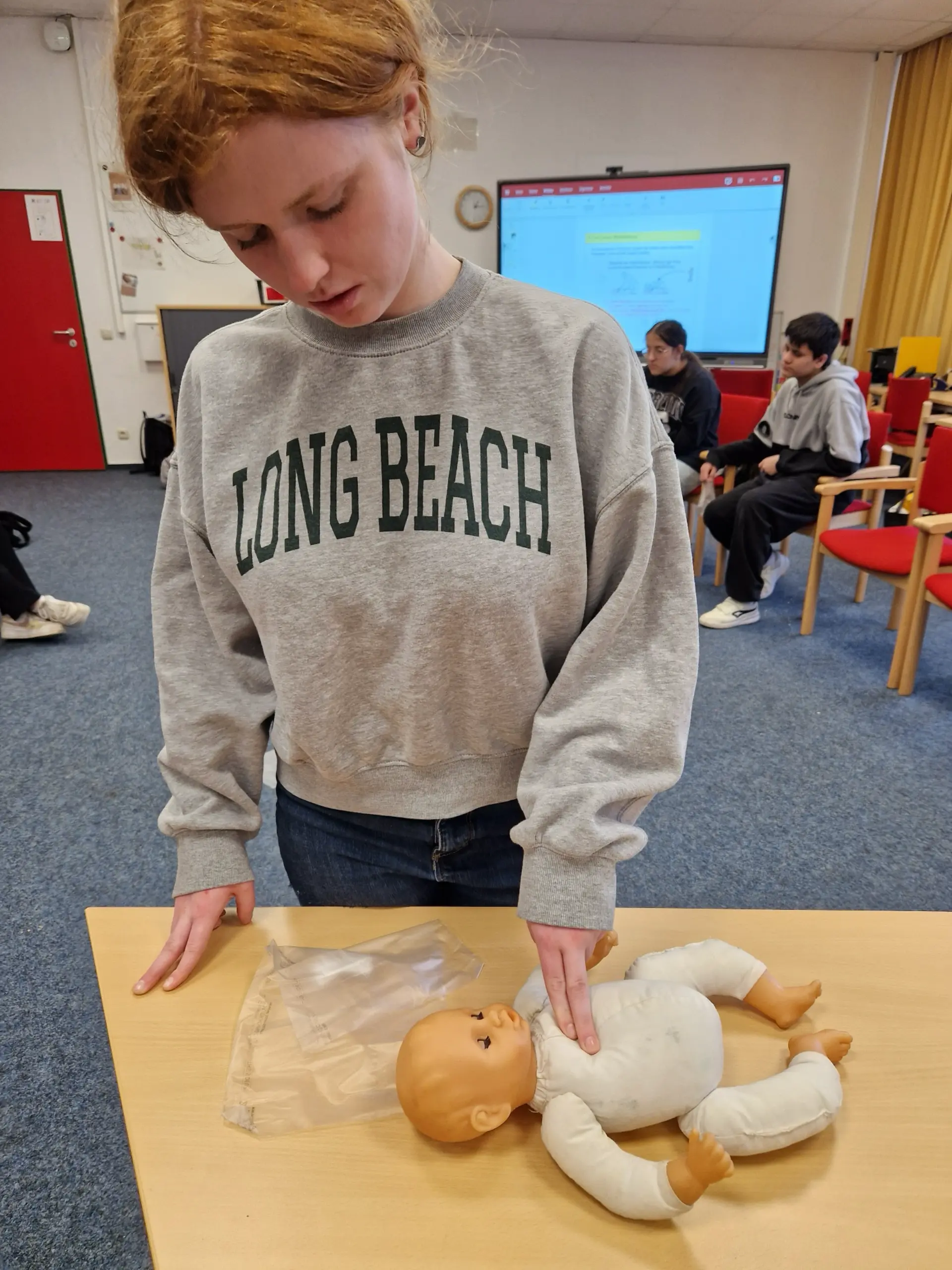 Eine Schülerin übt an einer Kinderpuppe